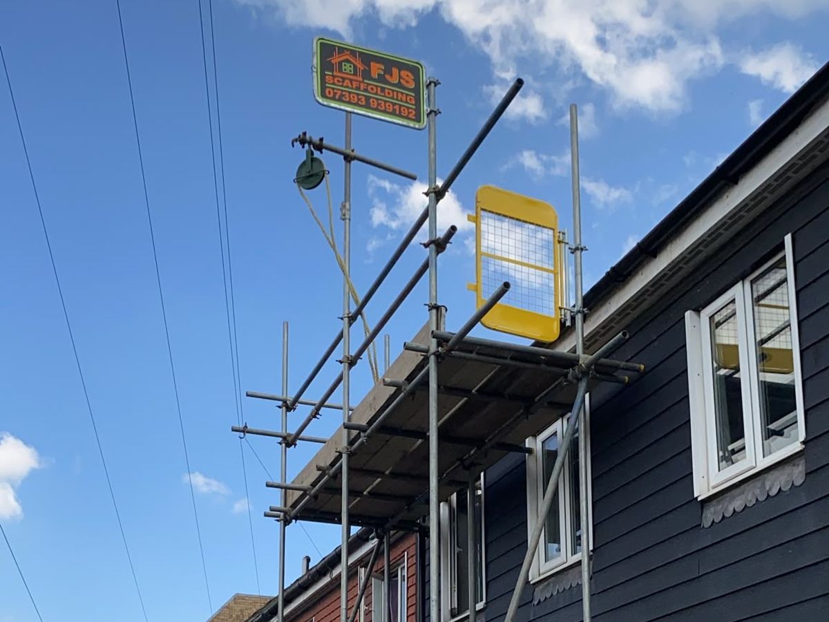 FJS scaffold with hoist and safety gate on a house